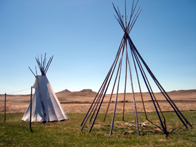 Two American Indian Teepee replicas with Fossil Hills in the background.
