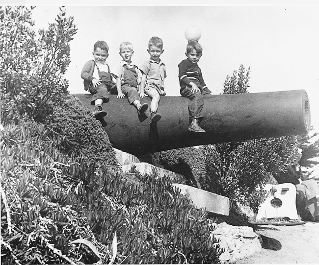 Children posing on obsolete army cannon