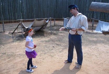 A young girl stands near a Civil War Prisoner