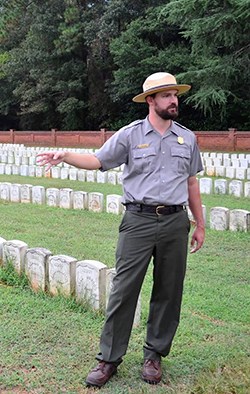 Park ranger stand near large number of Civil War graves