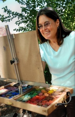 A woman paints at an easel