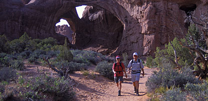 Hikers return from a visit to Double Arch