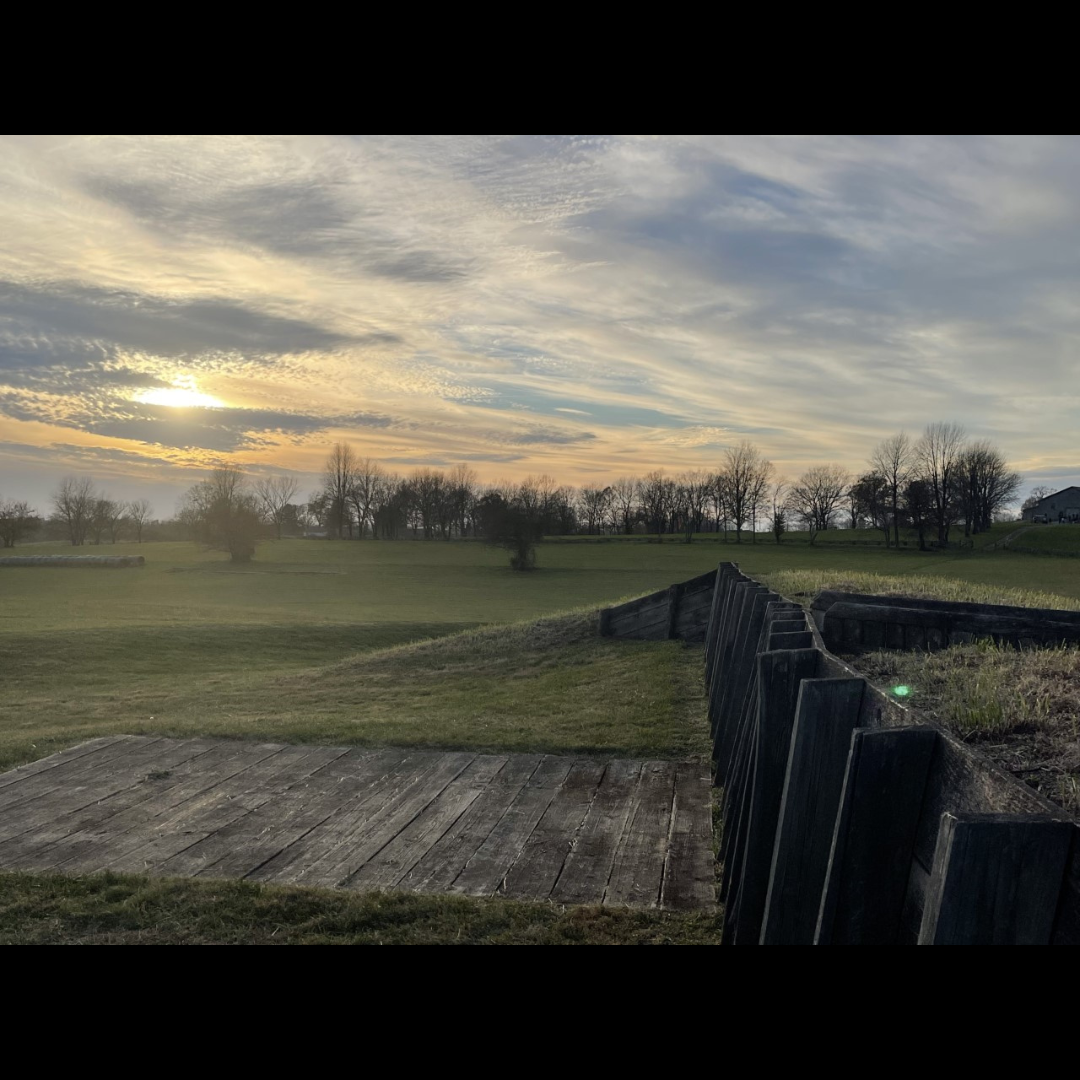 A photograph of the modern reconstruction of Fort Putnam at Camp Nelson- pictured is a wood retaining wall and a grass covered hill.