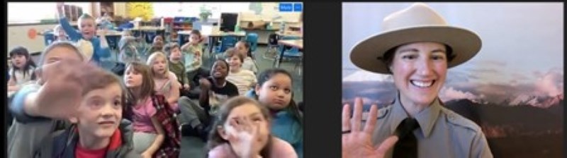 A woman in a park ranger uniform speaks with a class of young students on a web call.