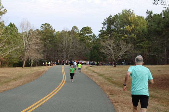 A person runs toward a group of runners on the loop road.