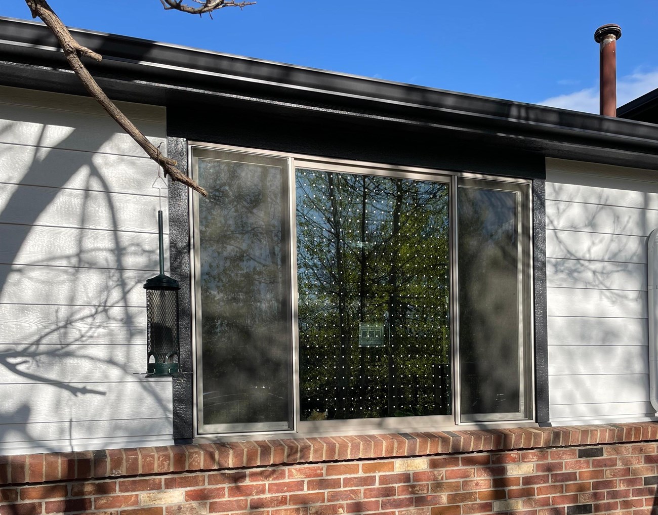 a residential house with a window that has rows of small dots along the surface