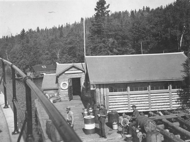 lakeside store with barrels in front and men standing next to them