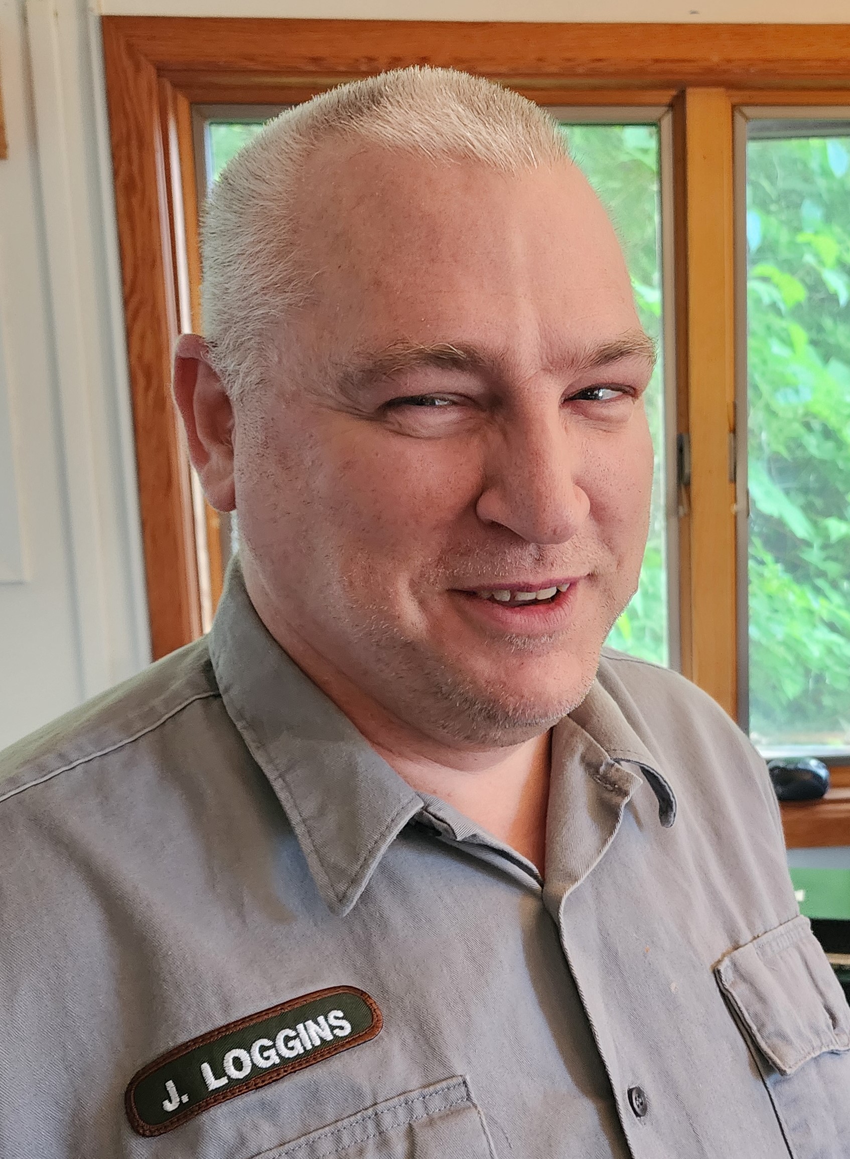 a man wearing a National Park Service shirt smiles for the camera