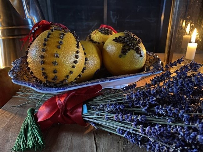 A bowl of finished pomanders - oranges with designs made of cloves.