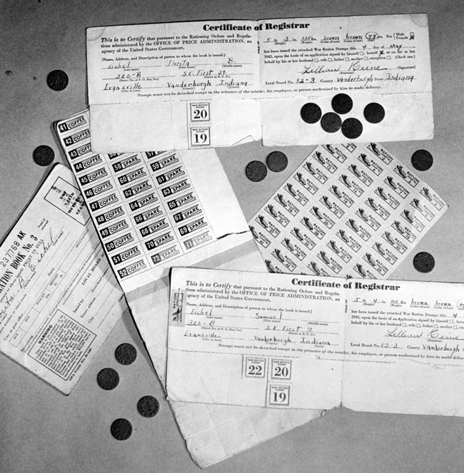 Black and white photo of pieces of paper with stamps  on them and black tokens