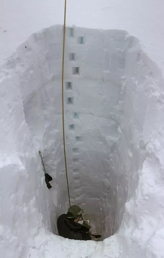 Man sitting in a snow pit