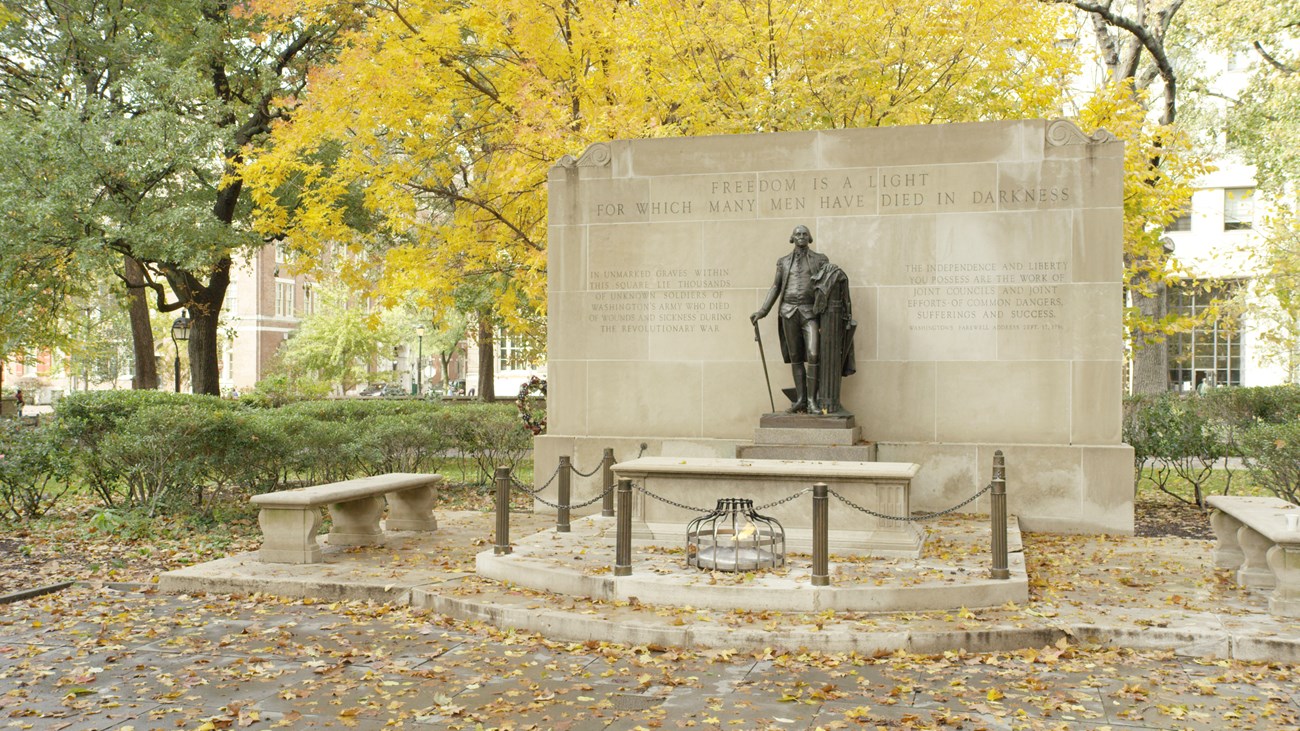 Bronze statue of George Washington overlooking a limestone sarcophagus