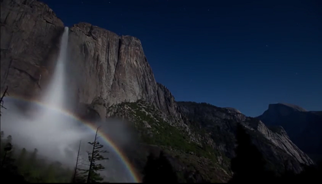 Rainbow formed on the mist of a waterfall at night