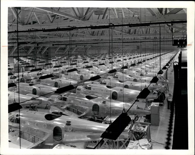 Black and white overhead photo of hangar with rows of planes