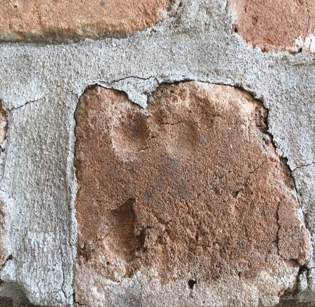 finger impression on red brick
