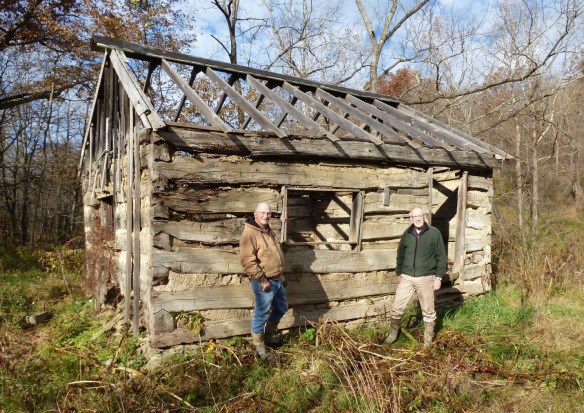 a wooden frame  of a home with two men standing in front of it