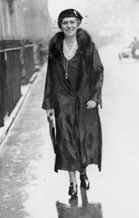 lady wearing a dress, fur coat and hat