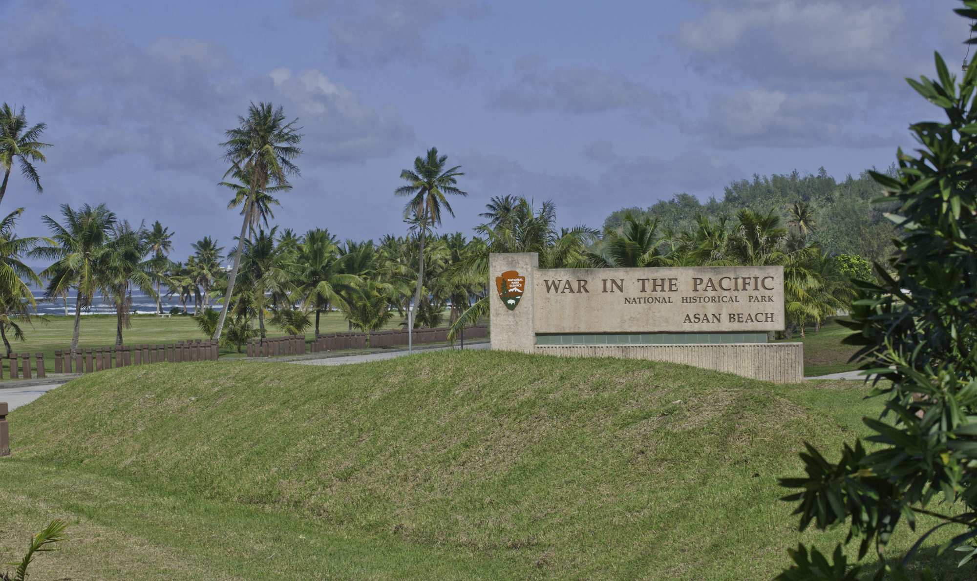 War in the Pacific National Historic Park welcome sign sits behind a green grassy hill