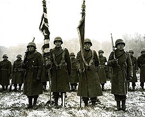 Two Japanese-American color guard and color bearers of the 442nd RCT stand at attention during their citation for rescuing the Lost Battalion. France. November 12, 1944.