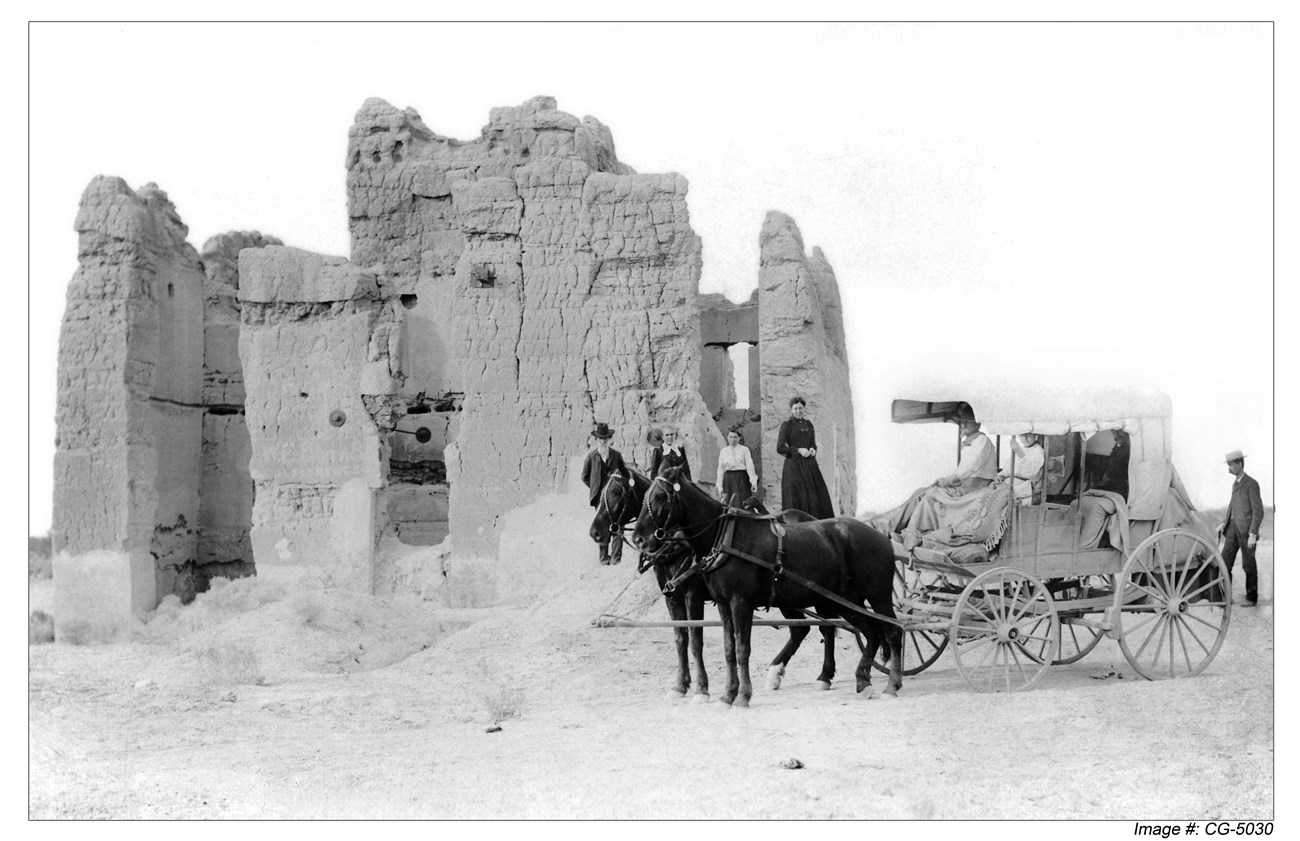 Historic black and white photo of visitors in a horse drawn carriage at abode ruins