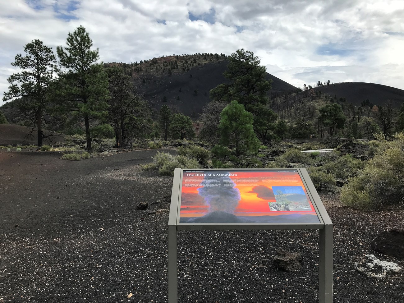 Photo of a trailside sign in a volcanic landscape