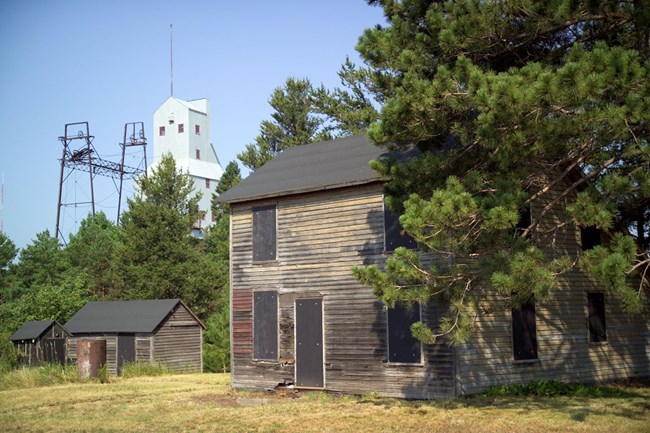 Historic wooden house in front of an industrial building