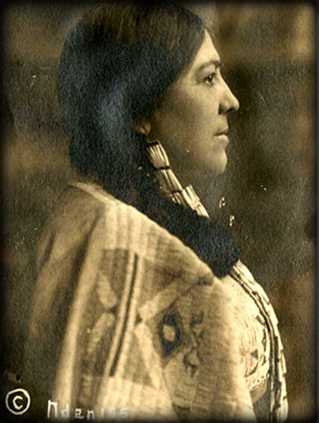 Studio photo of Mary Bottineau Baldwin in profile facing right wearing traditional Ojibway dress with hair in braid.