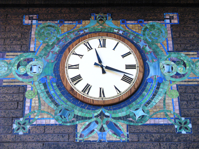Clock with a colorful mosaic around it.