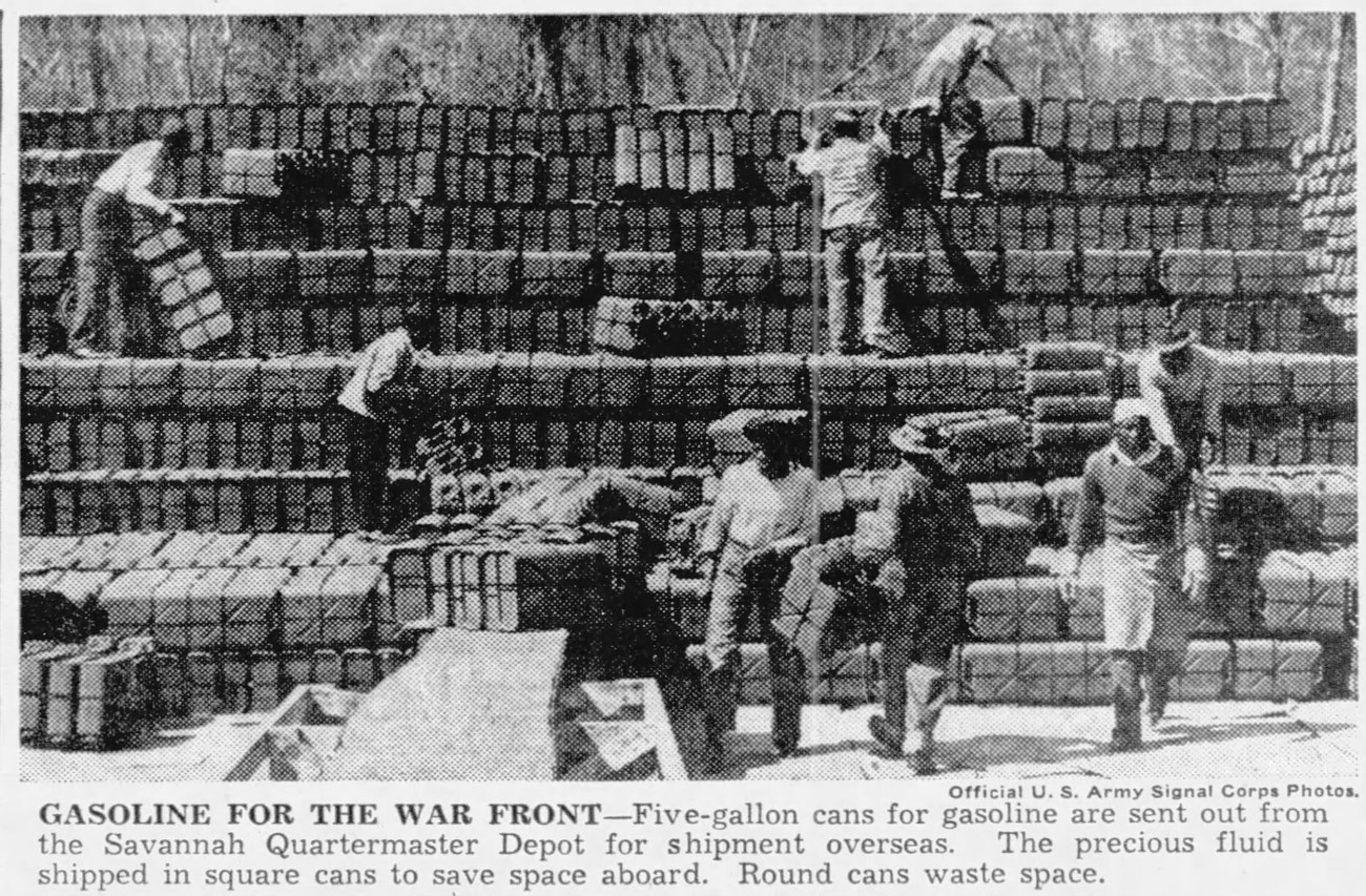 Black and white photograph of African American men moving gasoline cans