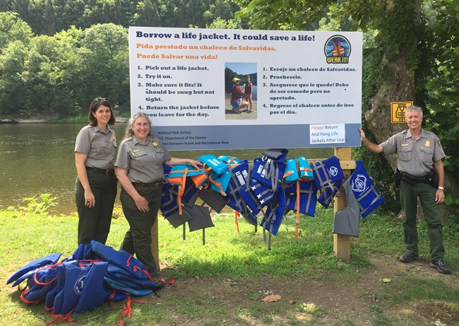 Park Rangers standing next to life jacket loaner station