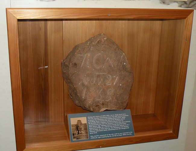 A large stone inside a glass case on a wall.