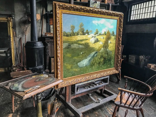 Landscape paining on easel and painting supplies