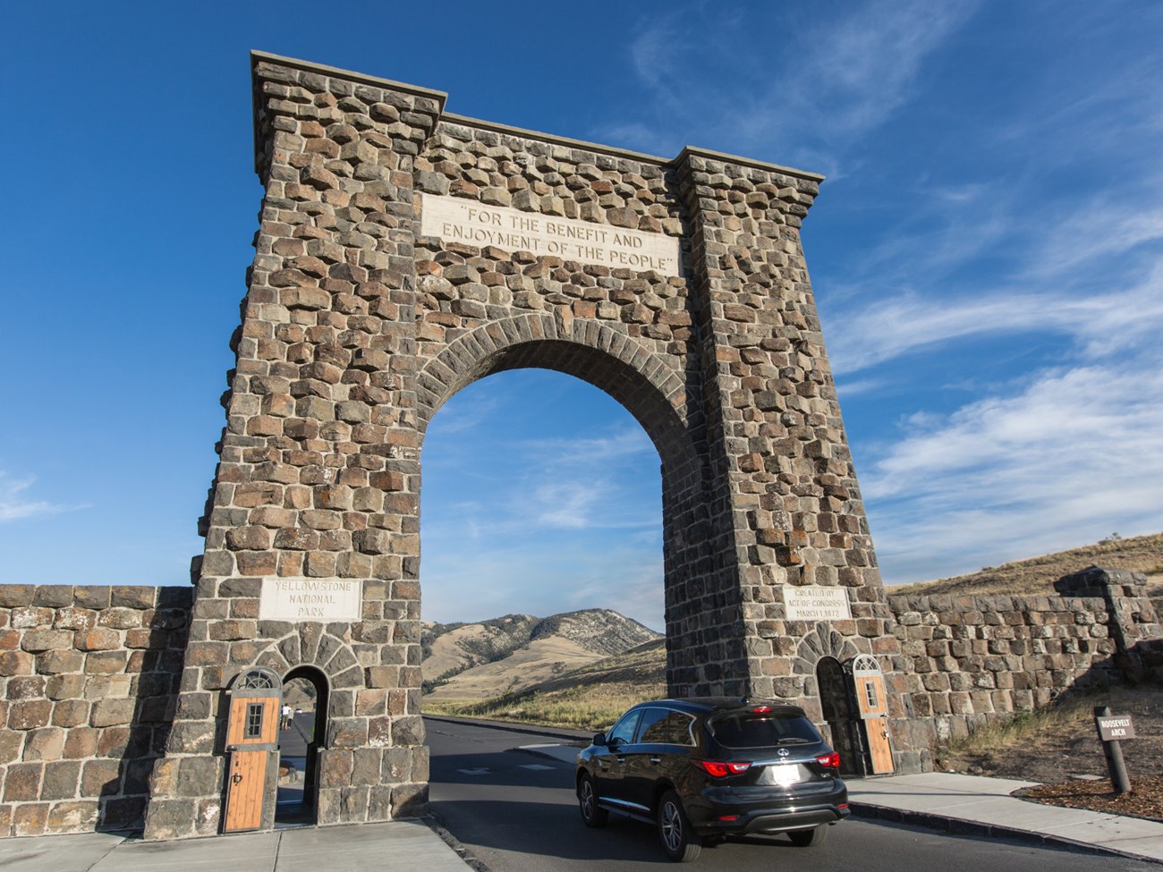 Car passing under a stone arch at Yellowstone