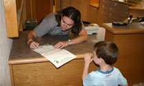 Ranger signs a child's Junior Ranger certificate