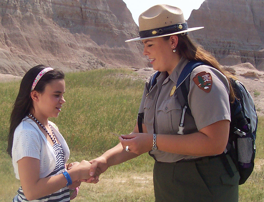 Teacher Ranger Jessica Dux awards a junior ranger badge. 