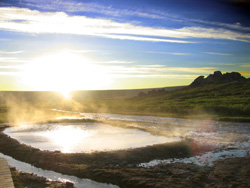 Steam rising from the pool at Serpentine Hot Springs as the sun sits on the horizon.