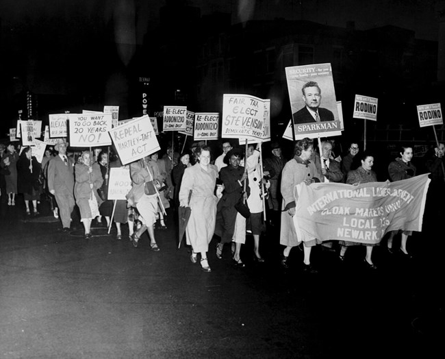 a group of ladies carrying signs and marching through the streets