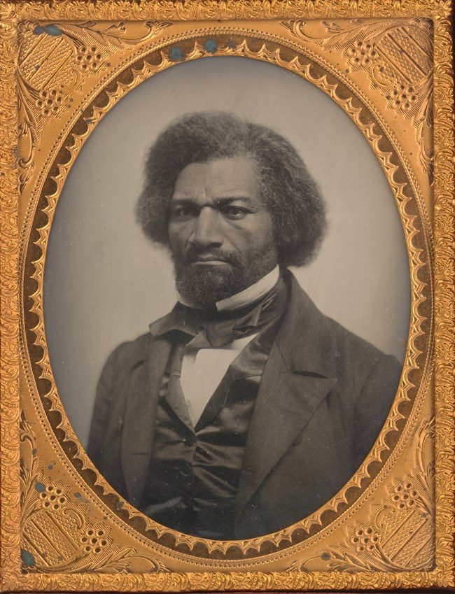 Black and white photograph of Frederick Douglass wearing a suit