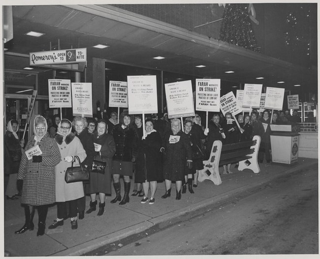 a group of women protesting outside of a department store and holding signs