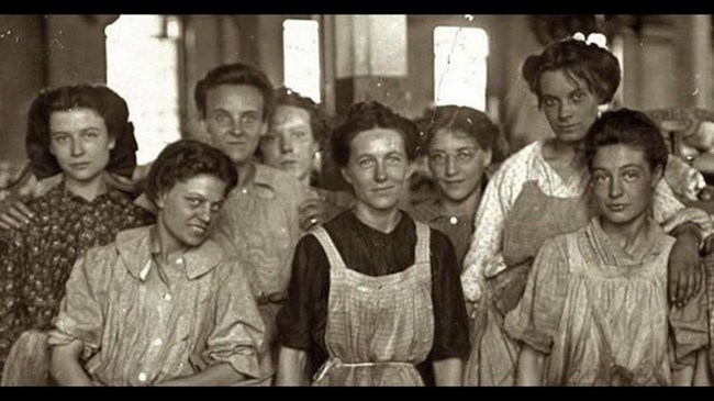 8 female cotton mill workers posing for the camera