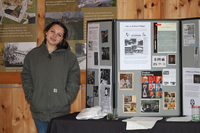 Lady in jacket stands next to folding board
