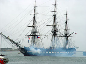 USS Constitution firing her cannons.