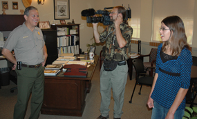 Contest winner Becky Loepky talks with Brown v. Board of Education National Historic Site Superintendent Dennis Vasquez as Scott Williams from Sunflower Journeys videotapes.