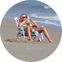 Woman sunbathing down by the ocean at South Beach.