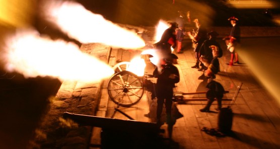 Spanish soldiers fire a two three pounder field pieces at night.