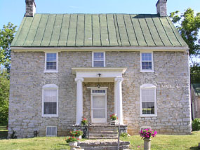 A small, Colonial American two-story stone house.