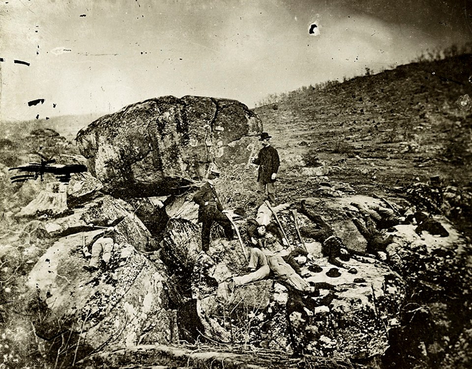 Historic view of the boulders of Devil's Den also shows the western slope of Little Round Top in the distance to the right.