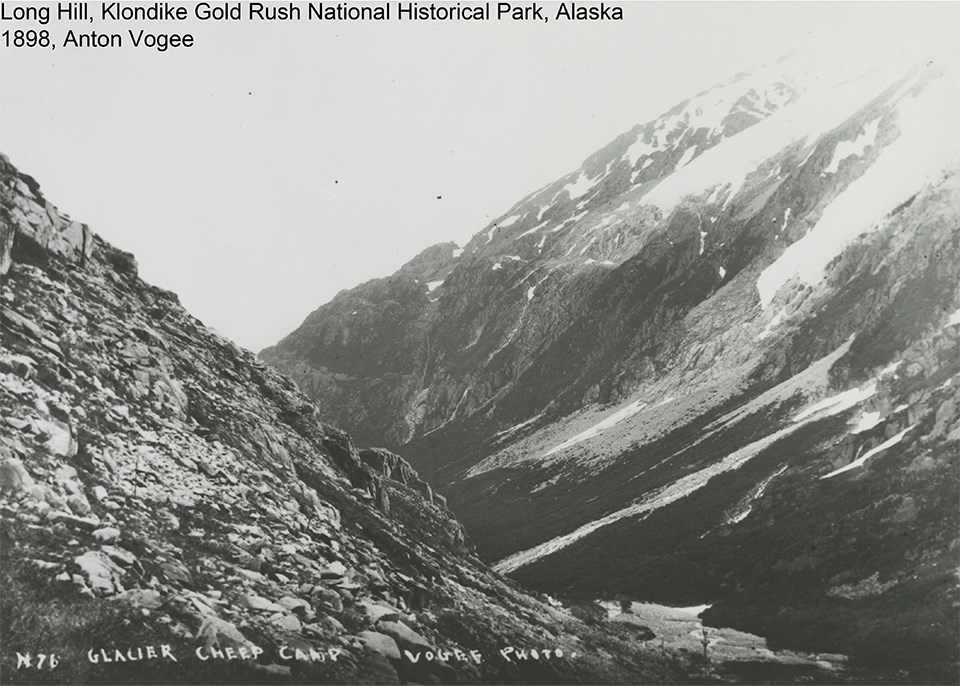 black and white image of rocky mountain with glaciers descending