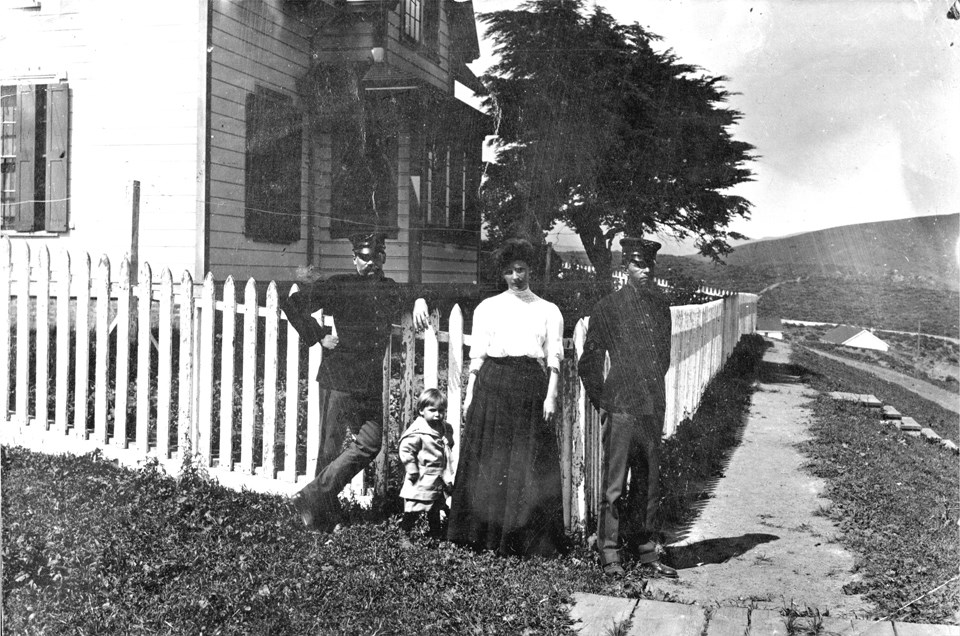 people posing in front of a cottage
