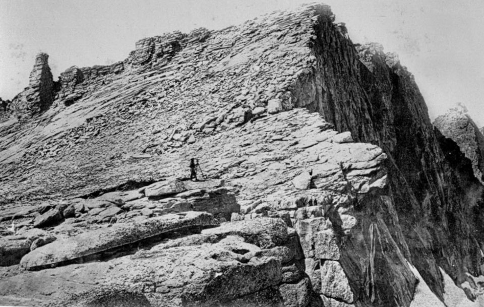 Man standing near top of mountain peak